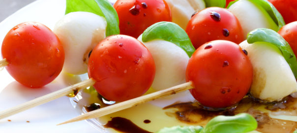 a caprese salad skewer with tomato, cheese, and basil