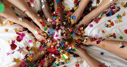 People sitting in a circile with their feet covered in start confetti.